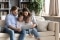 Una famiglia siede comodamente su un divano e guarda insieme un tablet