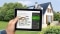 Tablet con calcolatore di modernizzazione, sullo sfondo: casa unifamiliare